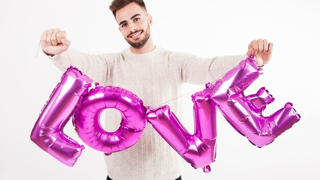 Kostenloses Foto mann, der ballon liebesschreiben zeigt