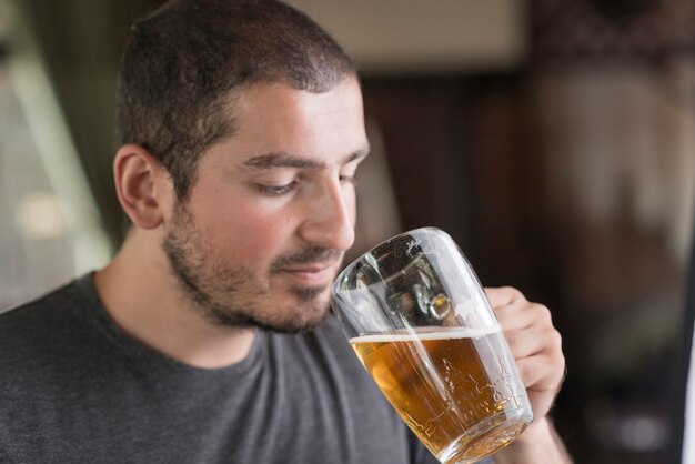 Mann, der Bier in der Bar genießt