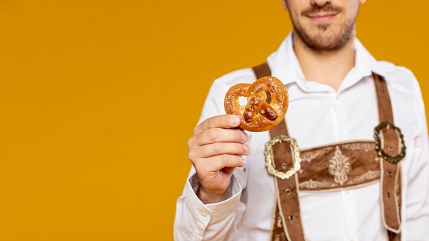 Mann, der Brezel mit Kopienraum hält