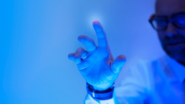 Mann, der den futuristischen blauen Bildschirm berührt