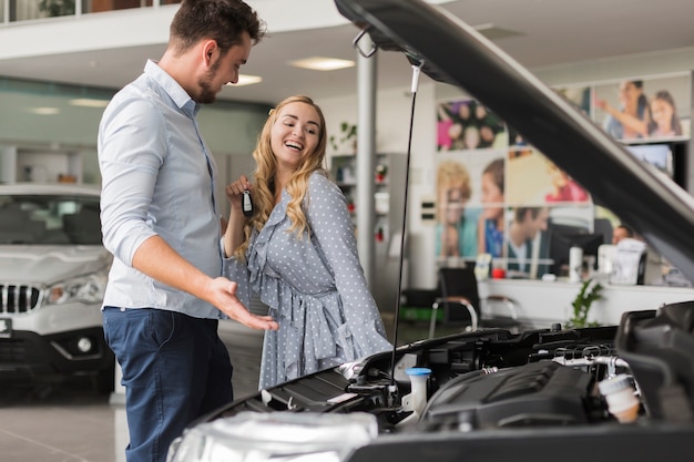 Mann, der der lächelnden Frau Automotor zeigt