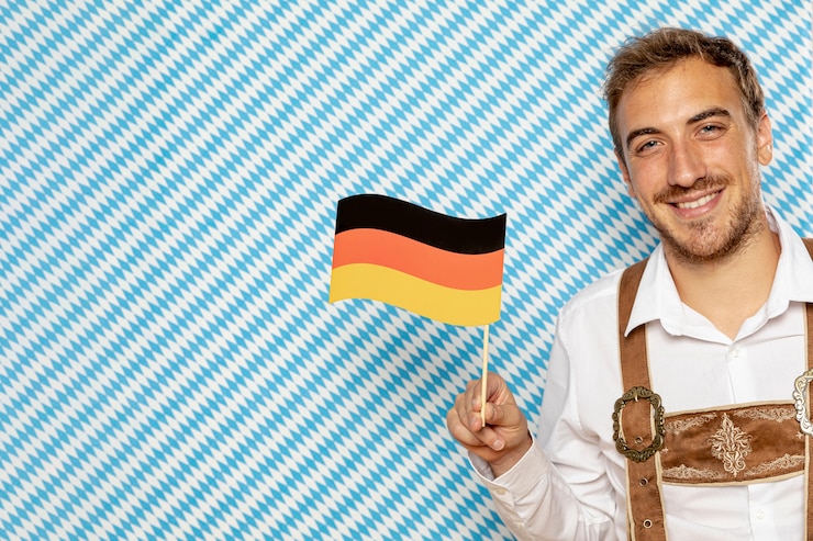 Kostenlose Foto mann, der deutsche flagge mit kopienraum hält