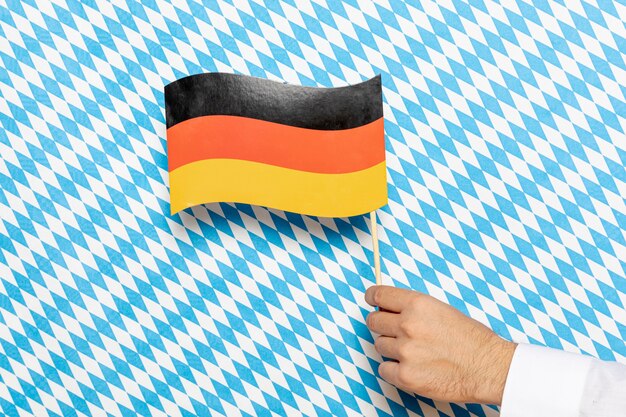 Mann, der deutsche Flagge mit kopiertem Hintergrund hält