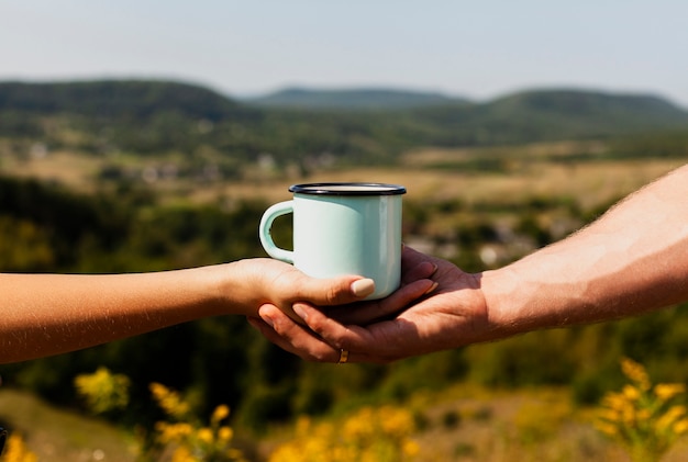 Mann, der die Hand der Frau und einen Tasse Kaffee hält