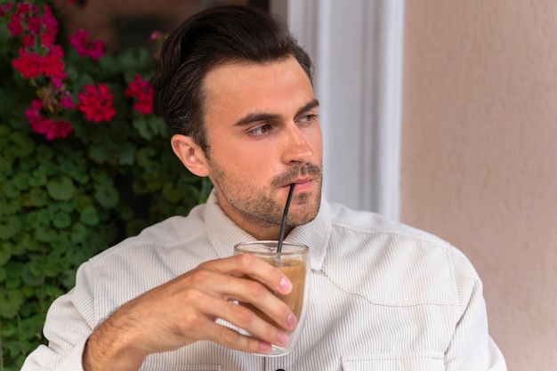 Mann, der draußen eine Eiskaffeepause hat