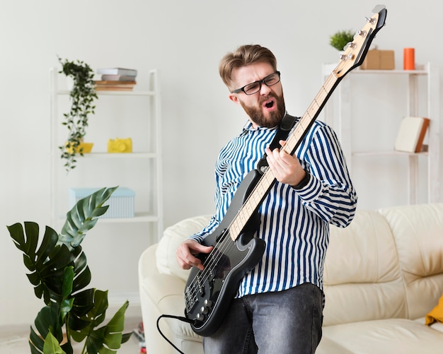 Mann, der e-gitarre zu hause genießt