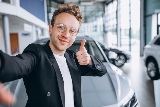 Mann, der ein Auto an einem Ausstellungsraum kauft