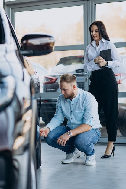 Kostenloses Foto mann, der ein auto wählt und mit verkäufer spricht