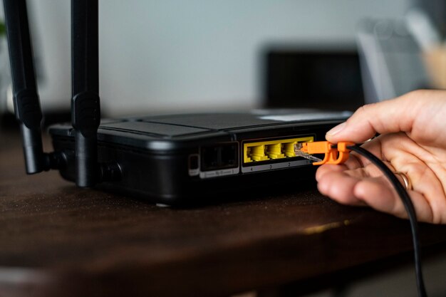 Mann, der ein Ethernet-Kabel an einen WLAN-Router anschließt