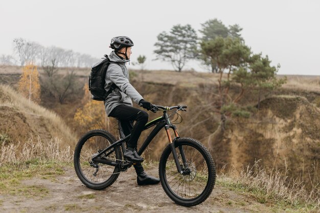 Mann, der ein Fahrrad auf Bergweg reitet