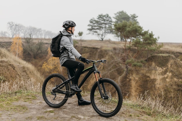 Mann, der ein Fahrrad auf Bergweg reitet