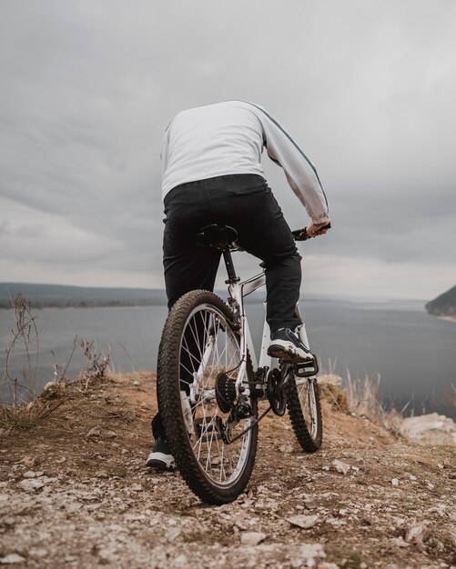 Mann, der ein Fahrrad draußen reitet