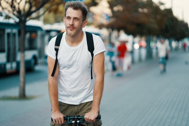 Mann, der ein Fahrrad in einer alten europäischen Stadt im Freien fährt