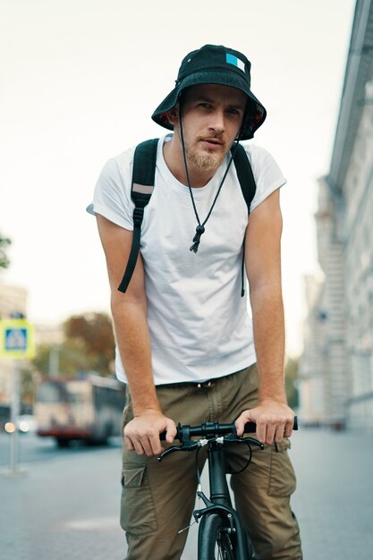 Mann, der ein Fahrrad in einer alten europäischen Stadt im Freien fährt