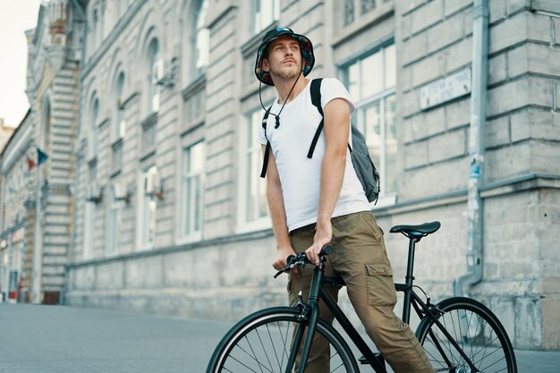 Mann, der ein Fahrrad in einer alten europäischen Stadt im Freien fährt