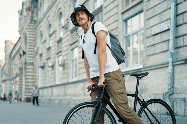 Mann, der ein Fahrrad in einer alten europäischen Stadt im Freien fährt