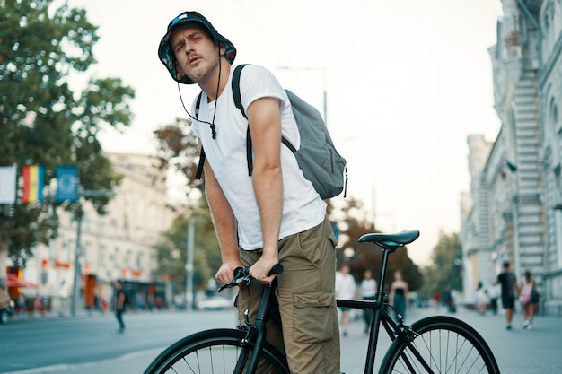 Mann, der ein fahrrad in einer alten europäischen stadt im freien fährt