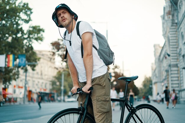 Mann, der ein Fahrrad in einer alten europäischen Stadt im Freien fährt