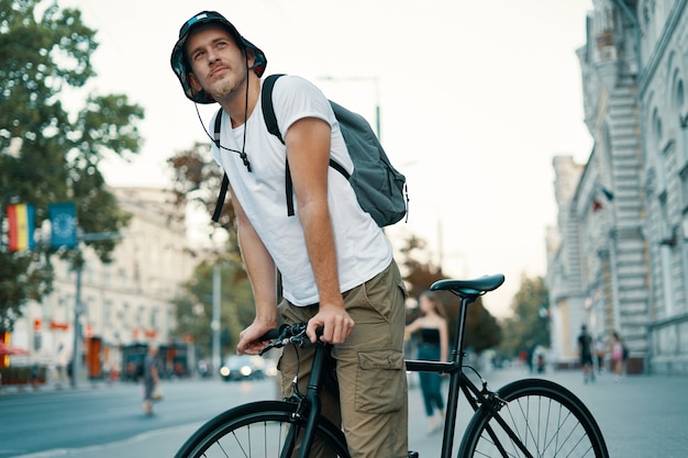 Mann, der ein Fahrrad in einer alten europäischen Stadt im Freien fährt