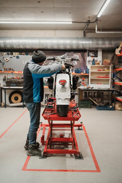 Mann, der ein Motorrad in einer modernen Werkstatt repariert