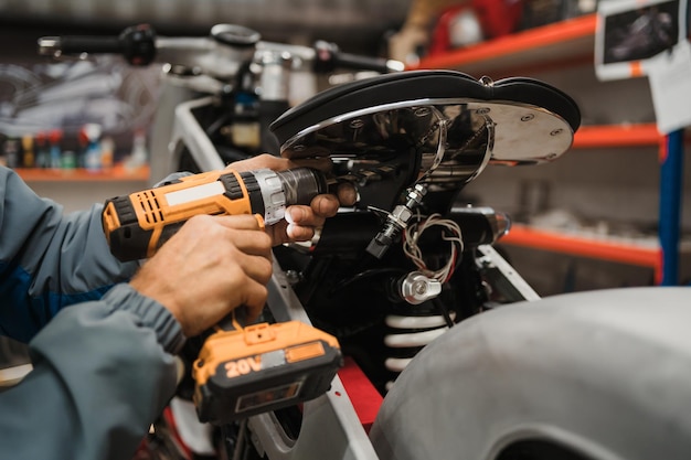 Mann, der ein Motorrad in einer modernen Werkstatt repariert
