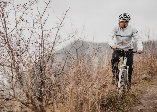 Mann, der ein Mountainbike in der speziellen Ausrüstung mit Kopienraum reitet