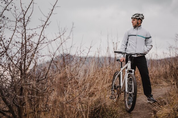 Mann, der ein Mountainbike in der speziellen Ausrüstung mit Kopienraum reitet