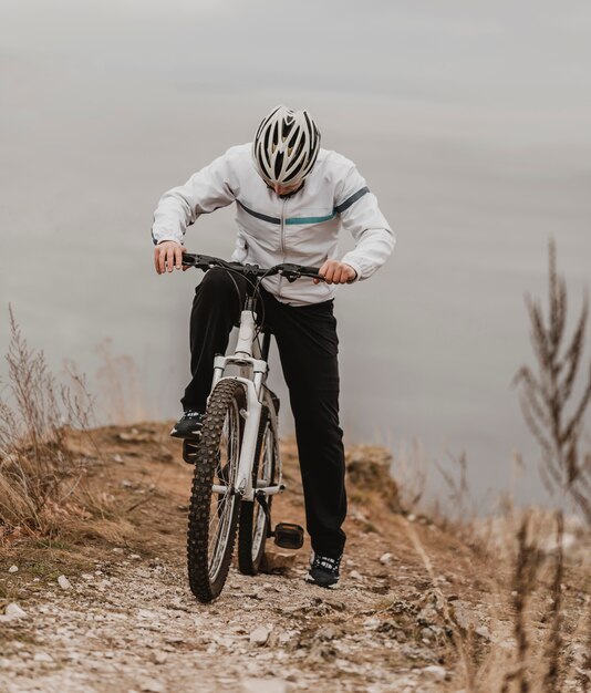 Mann, der ein Mountainbike in spezieller Ausrüstung reitet