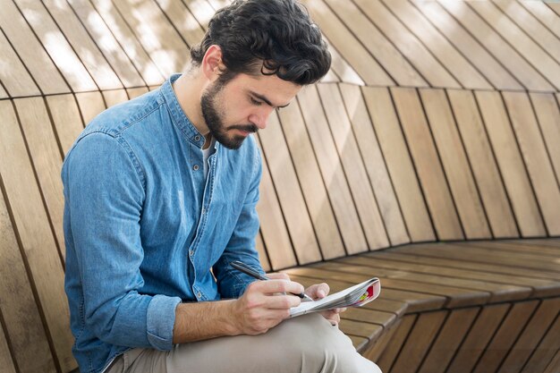 Mann, der ein Sudoku-Spiel auf Papier genießt