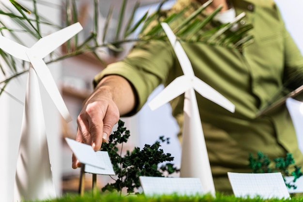 Kostenloses Foto mann, der ein umweltfreundliches windkraftprojektlayout repariert