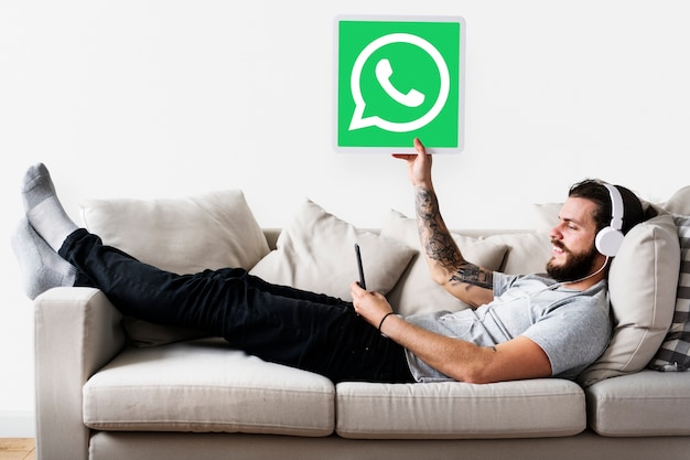 Kostenloses Foto mann, der ein whatsapp-botenikone zeigt