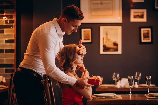 Mann, der eine Geschenkbox am Valentinstag in einem Restaurant gibt