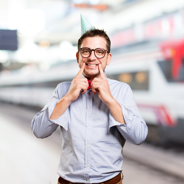 Mann, der eine rote Fliege und Partei-Hut trägt. Lächelnd.