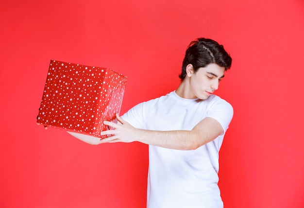 Mann, der eine rote Geschenkbox am Valentinstag anbietet