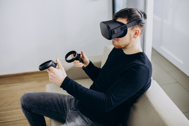 Mann, der eine VR-Brille benutzt und mit ihr spielt