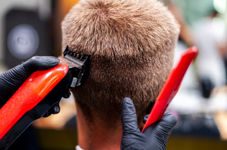 Kostenlose Foto mann, der einen haarschnitt mit rotem trimmer erhält