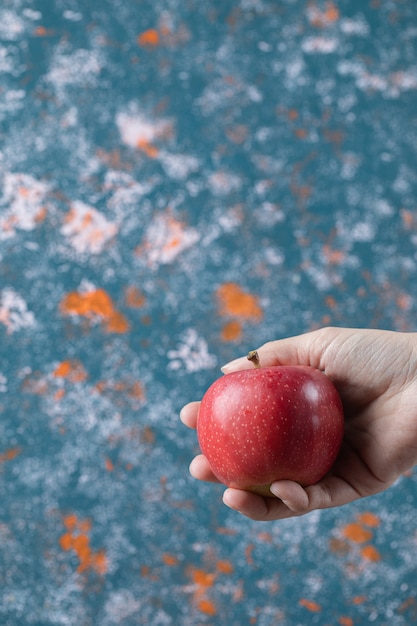 Kostenloses Foto mann, der einen roten apfel in der hand hält