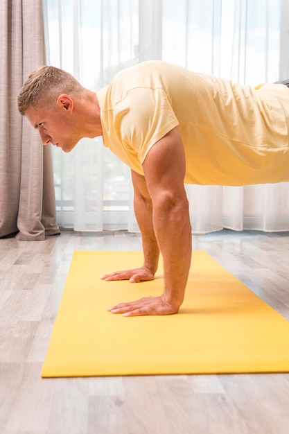 Mann, der fitness zu hause auf matte tut