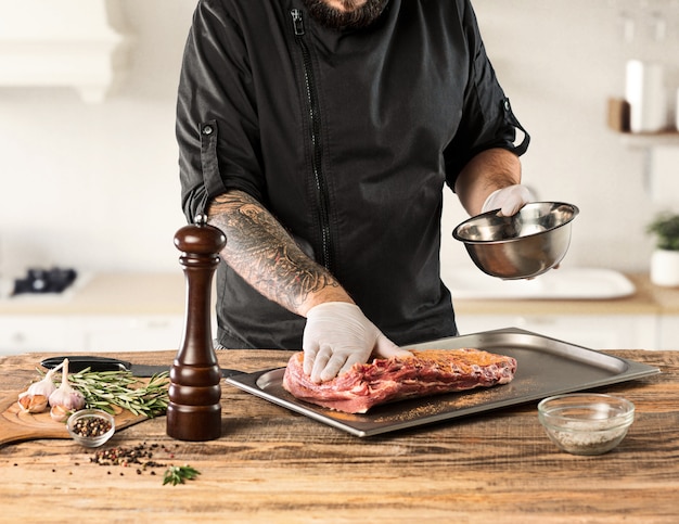 Mann, der Fleischsteak auf Küche kocht