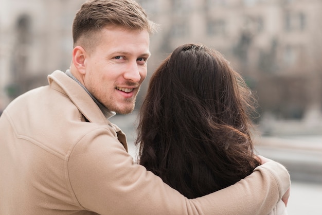 Kostenloses Foto mann, der frau beim aufstellen umarmt