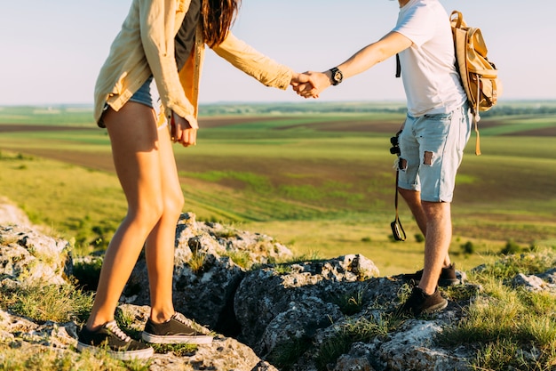 Mann, der Frau beim Gehen auf Felsen unterstützt