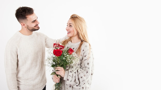 Kostenloses Foto mann, der frau mit blumenstrauß betrachtet