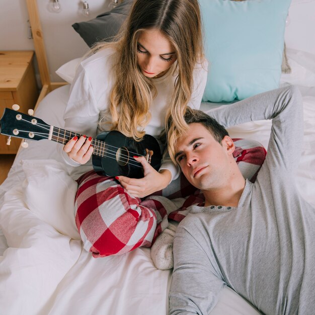 Mann, der Frau mit Ukulele betrachtet