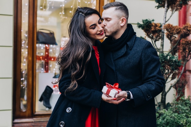 Mann, der Freundin für Weihnachtsgeschenk küsst