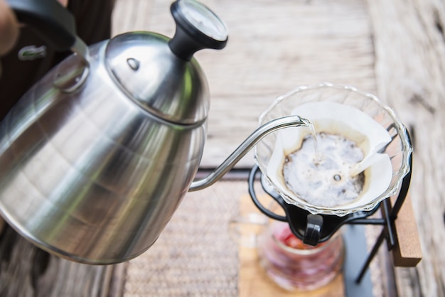 Mann, der frischen Kaffee des Tropfens in der Weinlesekaffeestube macht