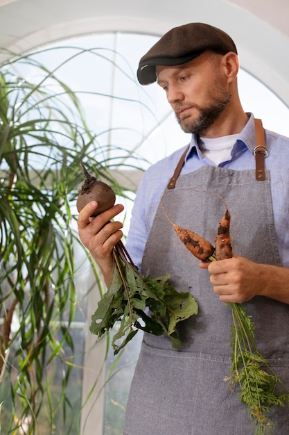 Mann, der Gemüse in seinem Indoor-Garten anbaut