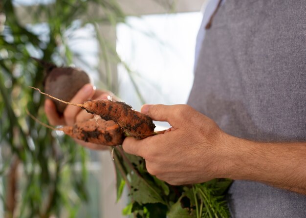 Mann, der Gemüse in seinem Indoor-Garten anbaut