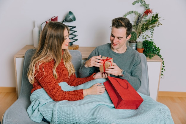 Kostenloses Foto mann, der geschenk von der frau betrachtet