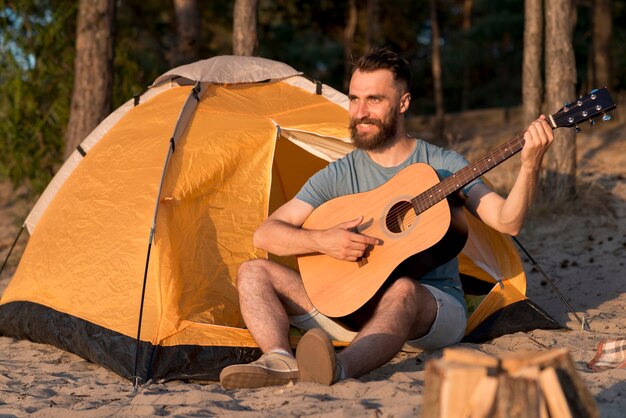 Mann, der Gitarre durch das Zelt spielt