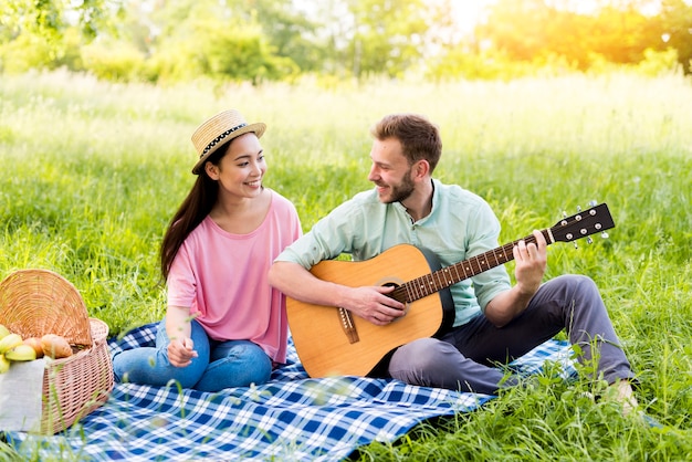 Mann, der Gitarre für Frau spielt